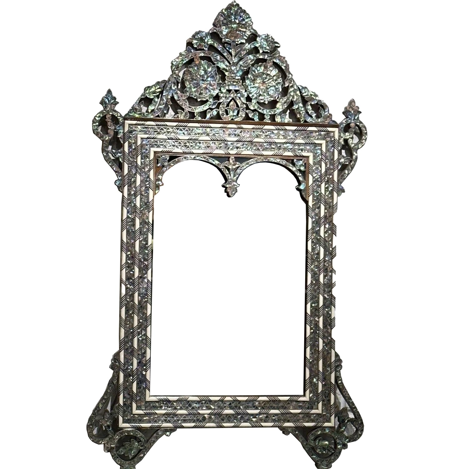 An ornate walnut wood mirror frame with hand-carved details, featuring abalone shell inlay and silver metal wire forming intricate arabesque motifs.