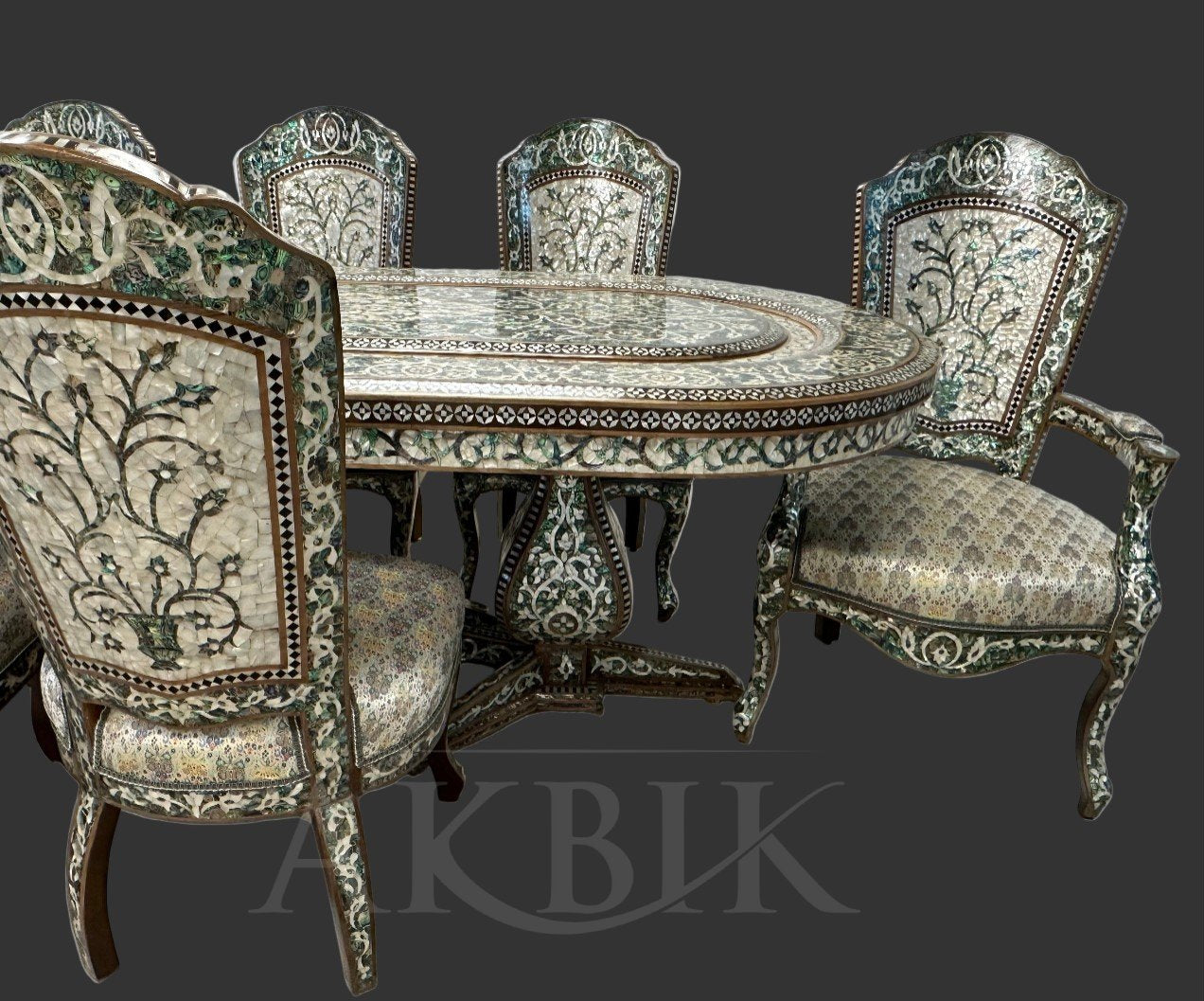 Decorative round table with matching chairs featuring intricate patterns on a dark background.