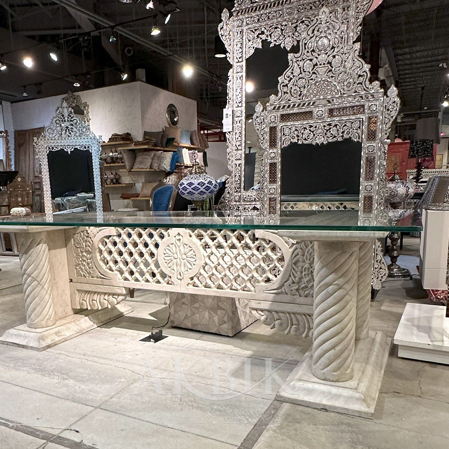 A rectangular marble dining table - DESK ALTERNATIVE with intricate carvings on the legs and a polished marble top, showcasing a luxurious design by Akbik furniture & design