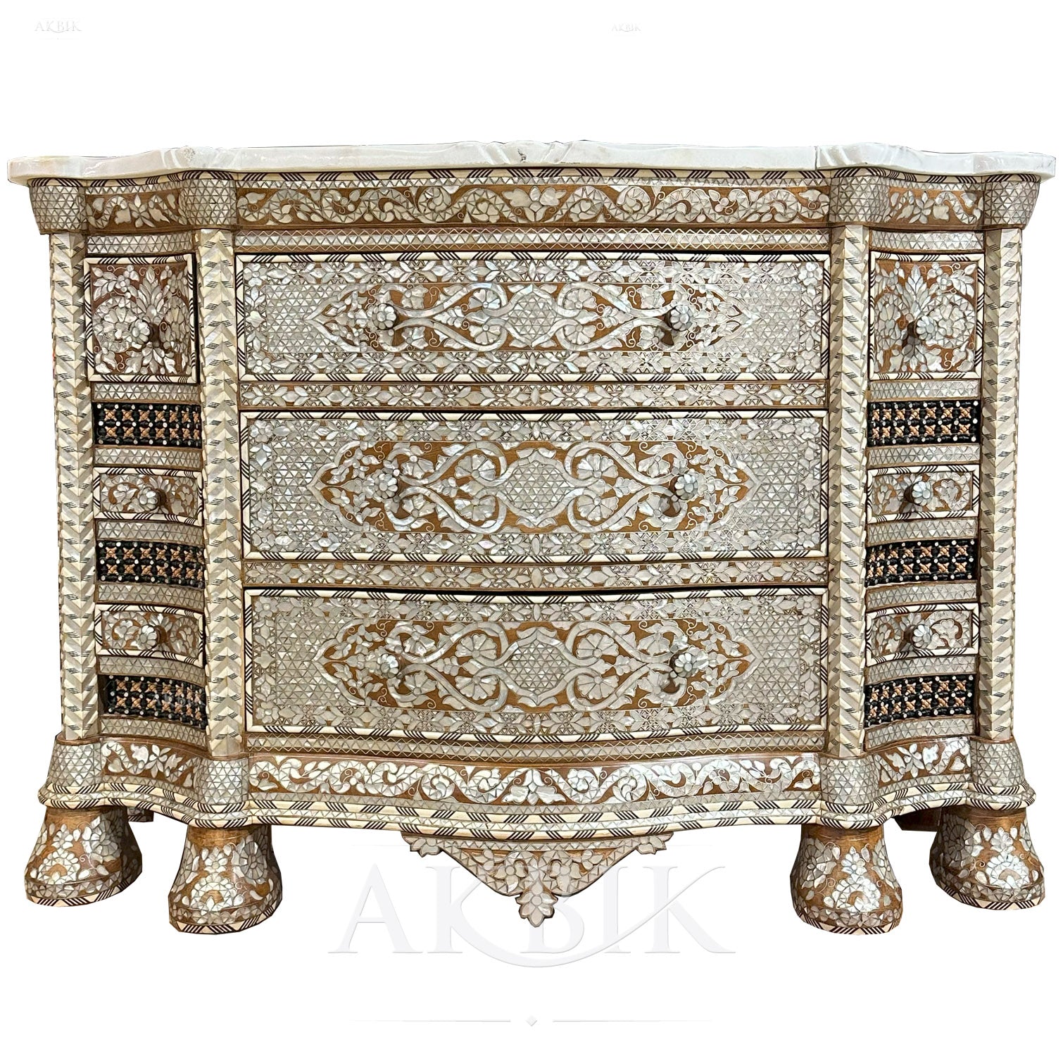 A Syrian chest of drawers with intricate mother-of-pearl inlay on a walnut wood frame, featuring carved details and ornate legs.
Details