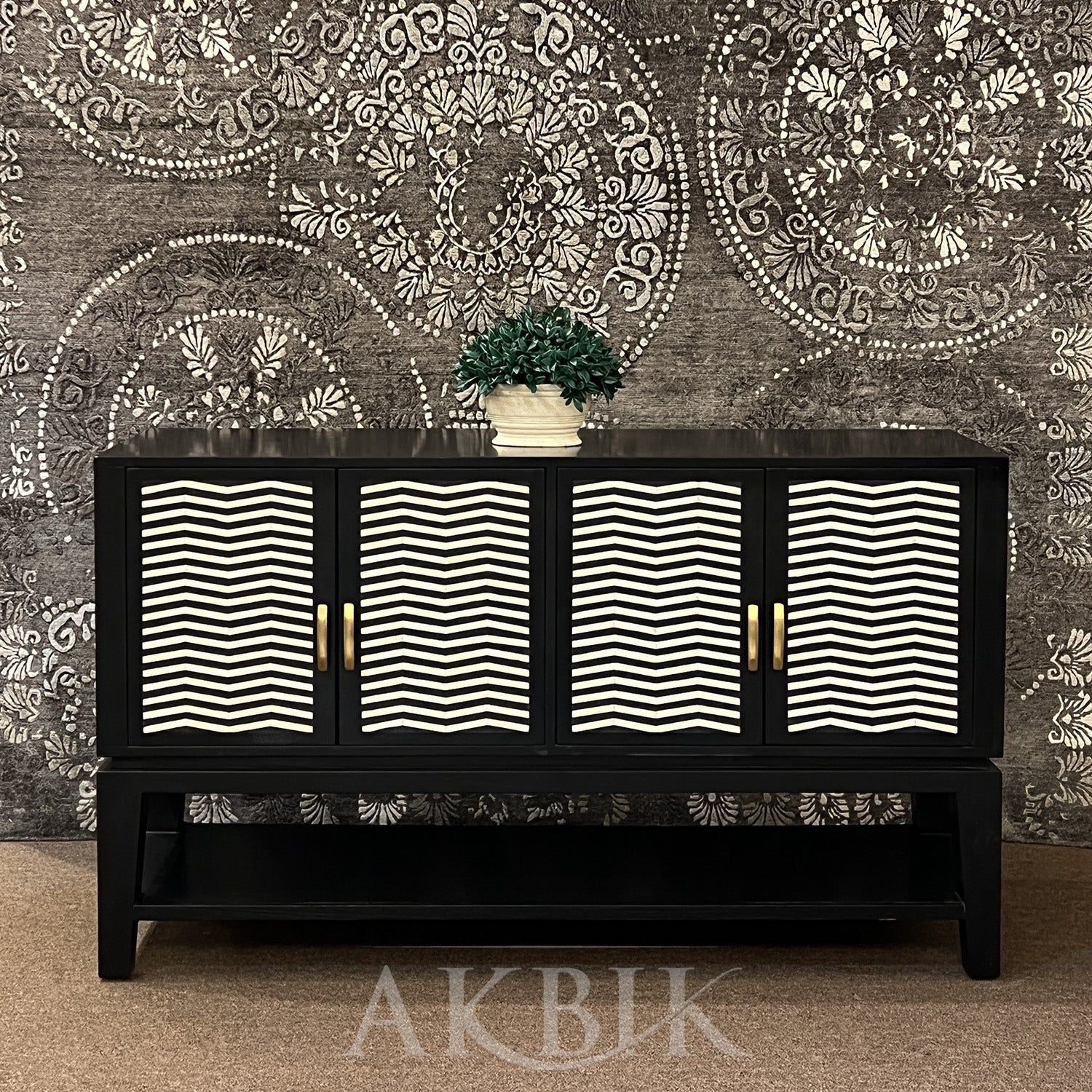 A black sideboard with a geometric chevron pattern on the front, featuring an inlay design and gold-colored handles.