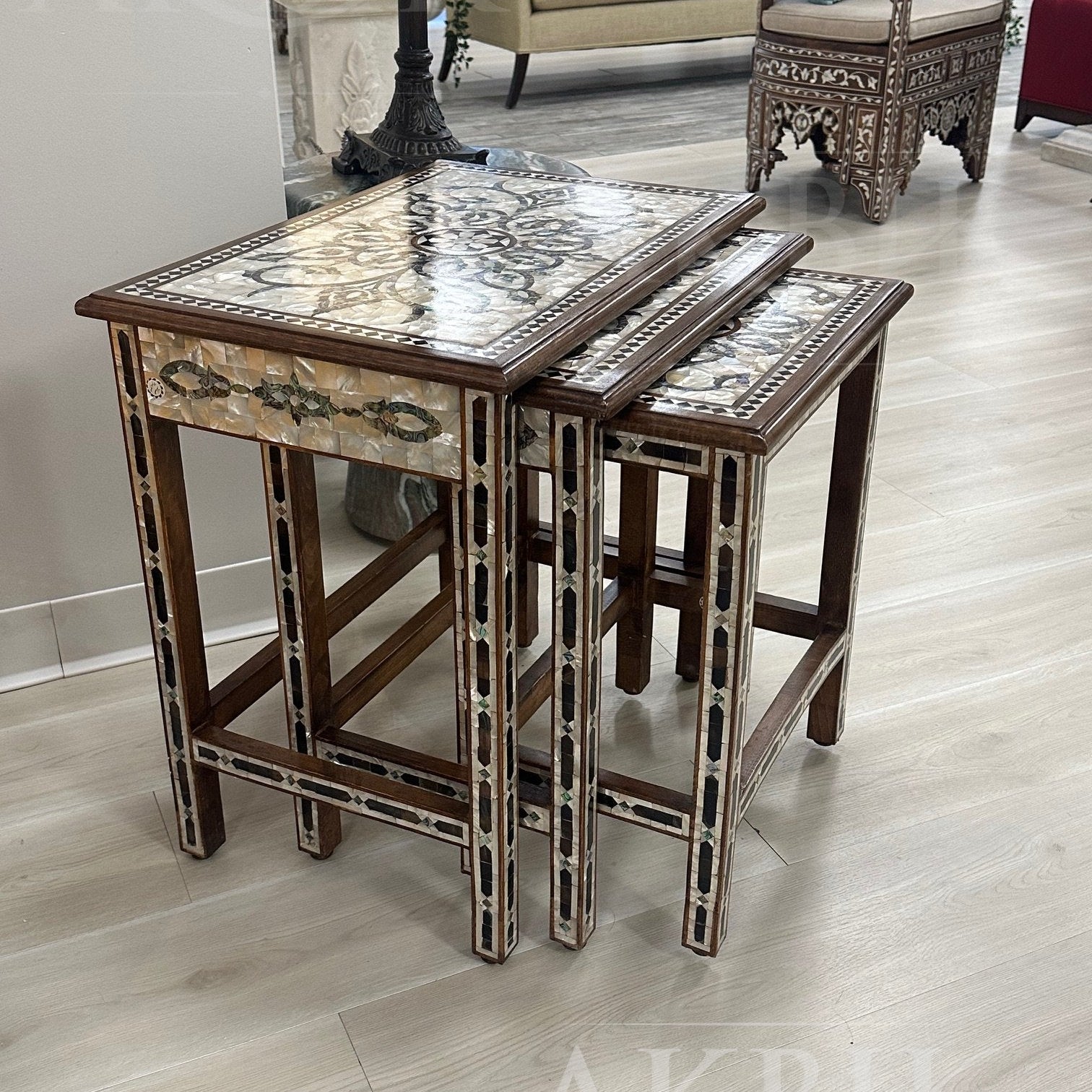 Decorative nesting tables with marble-like top and wooden base on a light wood floor.