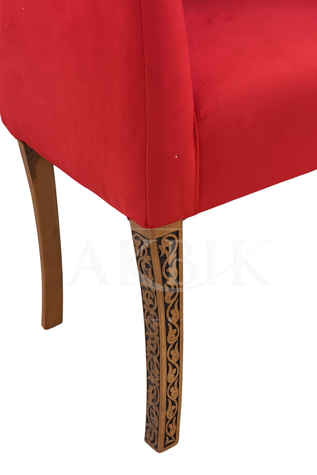 Close-up of a red upholstered chair with decorative wooden legs on a white background
