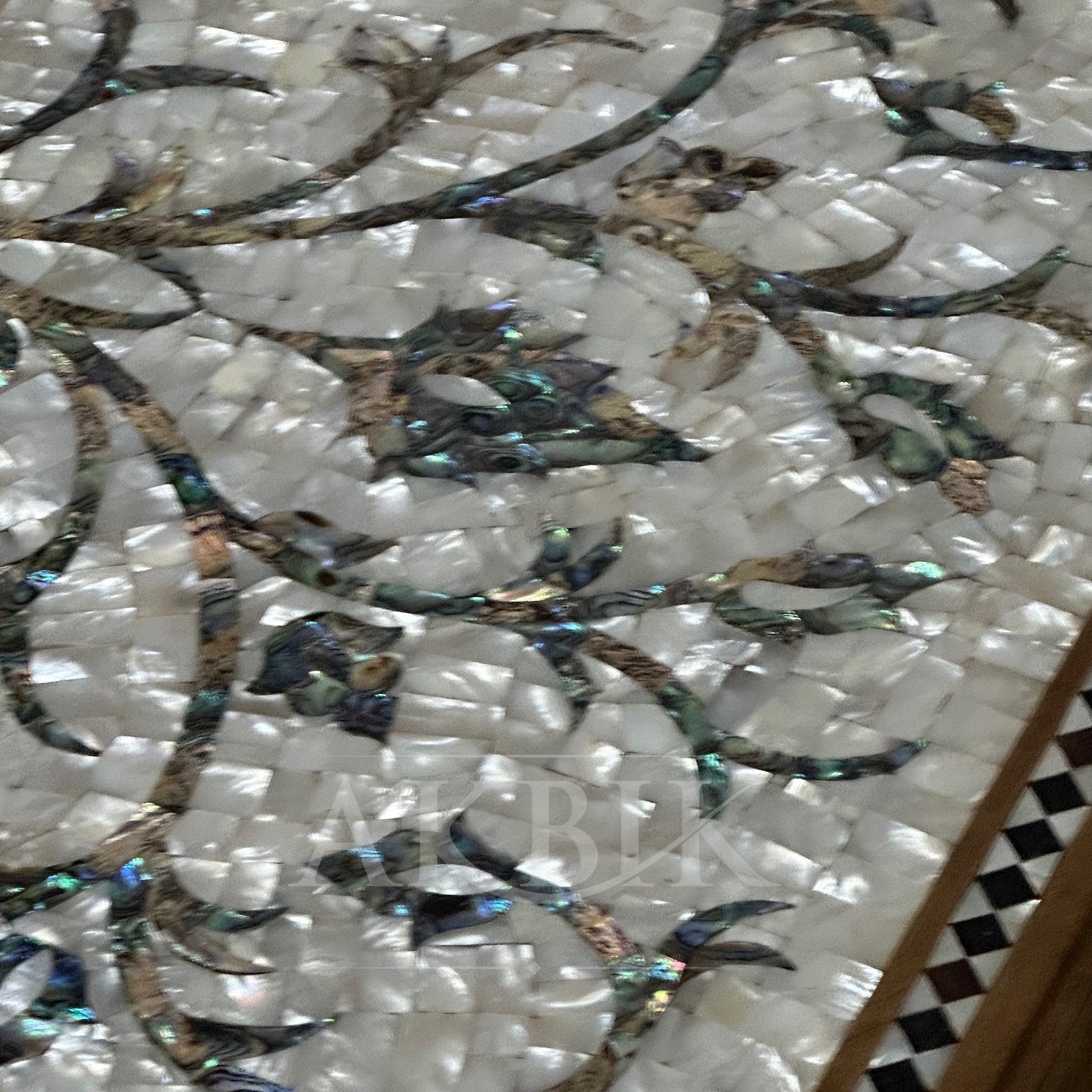 Close-up of a decorative mosaic floor with shell and stone patterns.