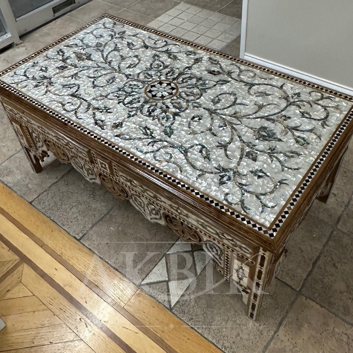 Decorative coffee table with intricate design on a tiled floor