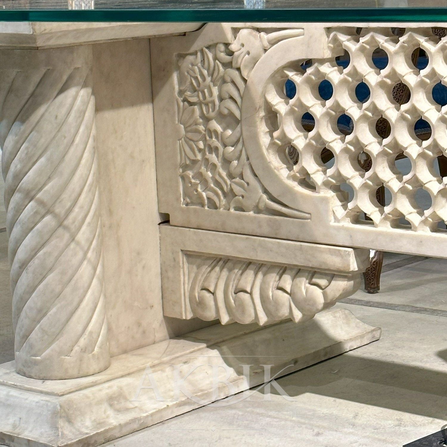 A rectangular marble dining table -  DESK ALTERNATIVE with intricate carvings on the legs and a polished marble top, showcasing a luxurious design by Akbik furniture & design 