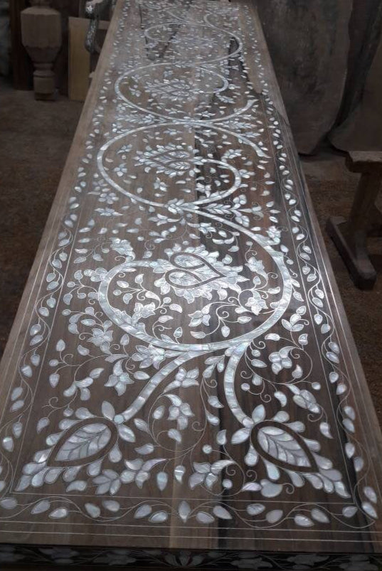 Decorative wooden panel with intricate carvings on a dark background