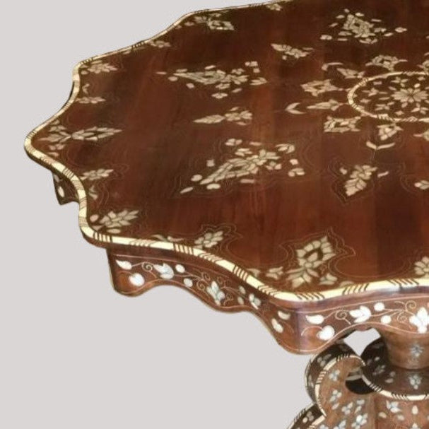 Decorative wooden table with intricate carvings on a light gray background