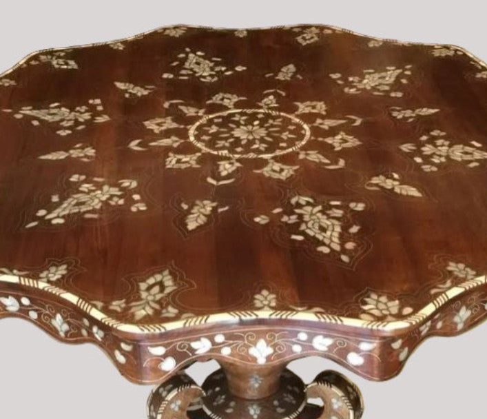 Decorative wooden table with intricate carvings on a plain background
