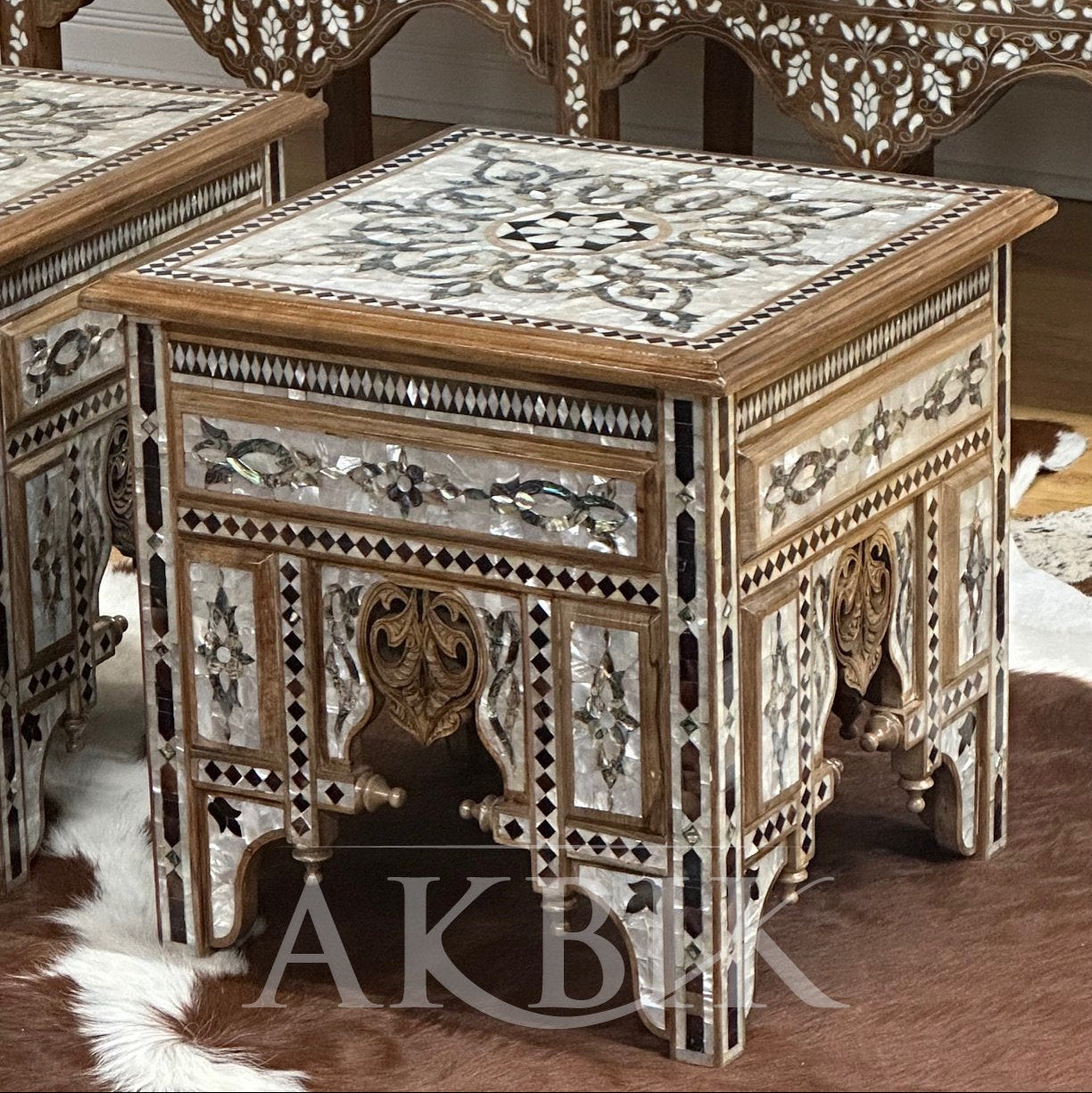 Decorative wooden table with intricate carvings and mosaic patterns, featuring the brand 'AKB'.