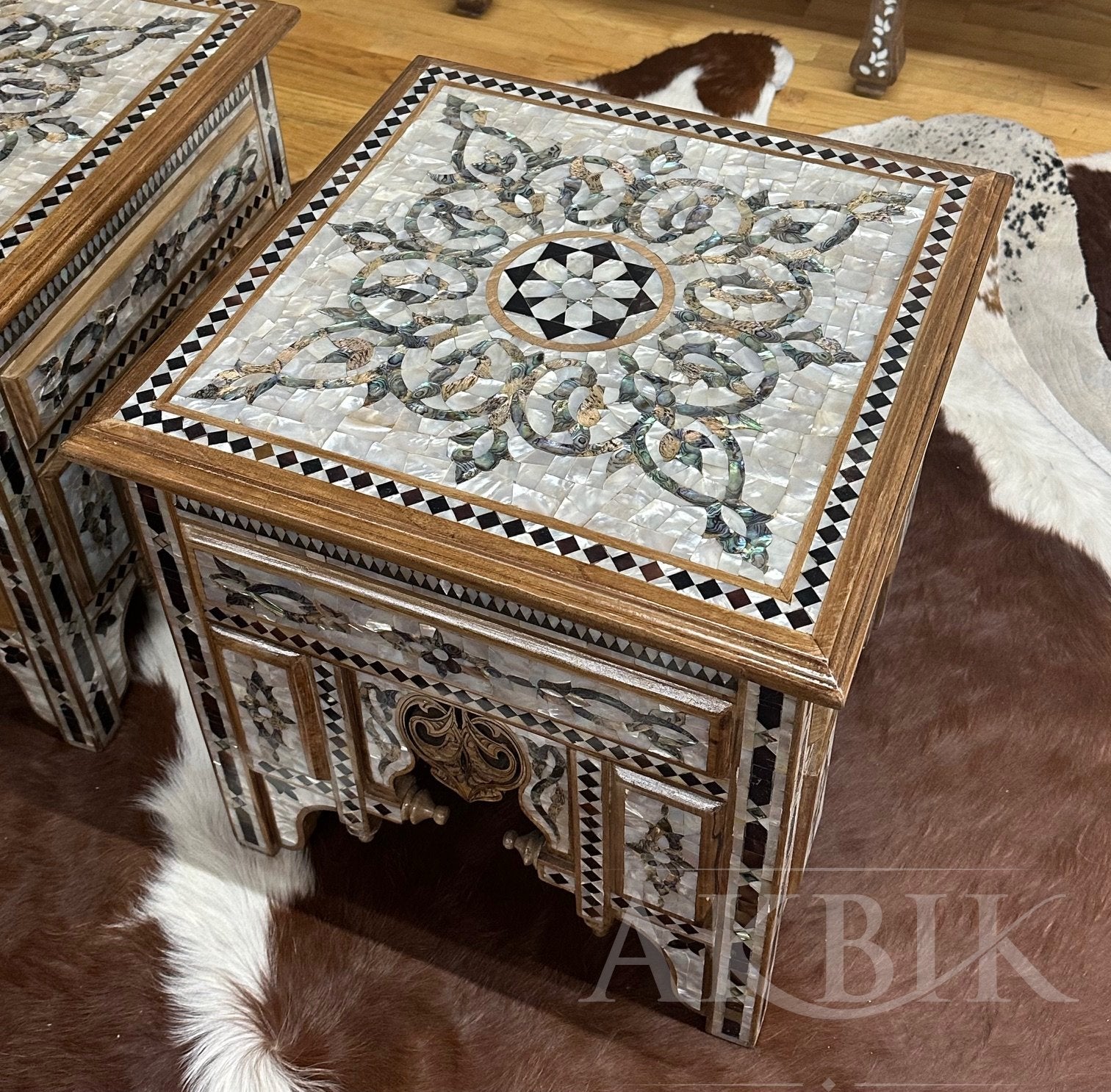 Decorative side table with mosaic top on a wooden floor, featuring the brand 'Altbik'.