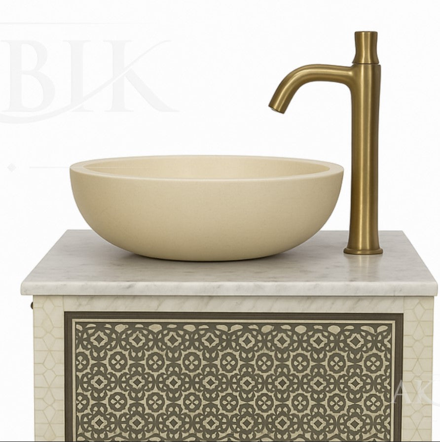 Beige sink with gold faucet on a decorative cabinet